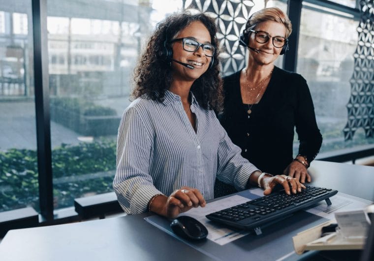 Two women smiling and looking at a computer screen