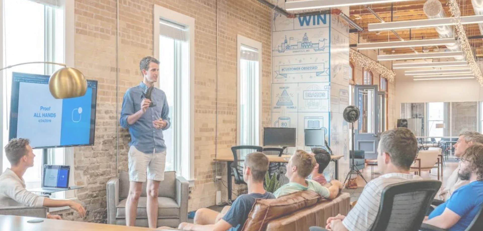 Background image of a man speaking in front of colleagues for BoldTek