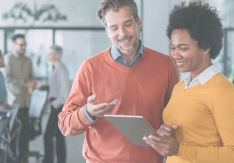 a man and a woman looking at a tablet