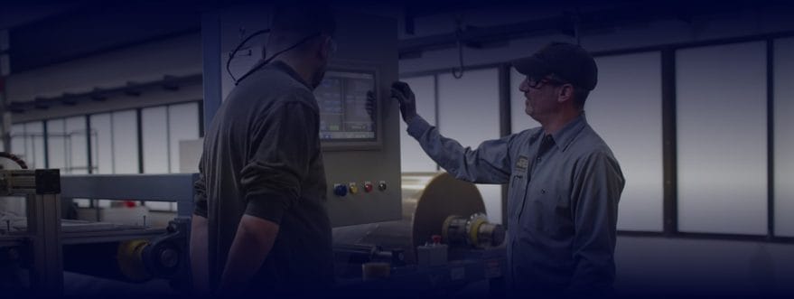 Background image for Boston Materials' case study showing two manufacturing workers operating a control panel on a factory floor