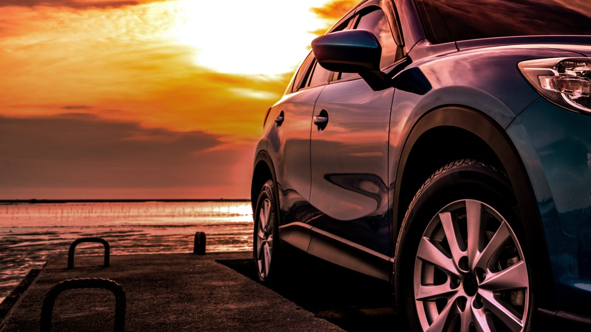 A close-up shot of a car with a sunset in the background