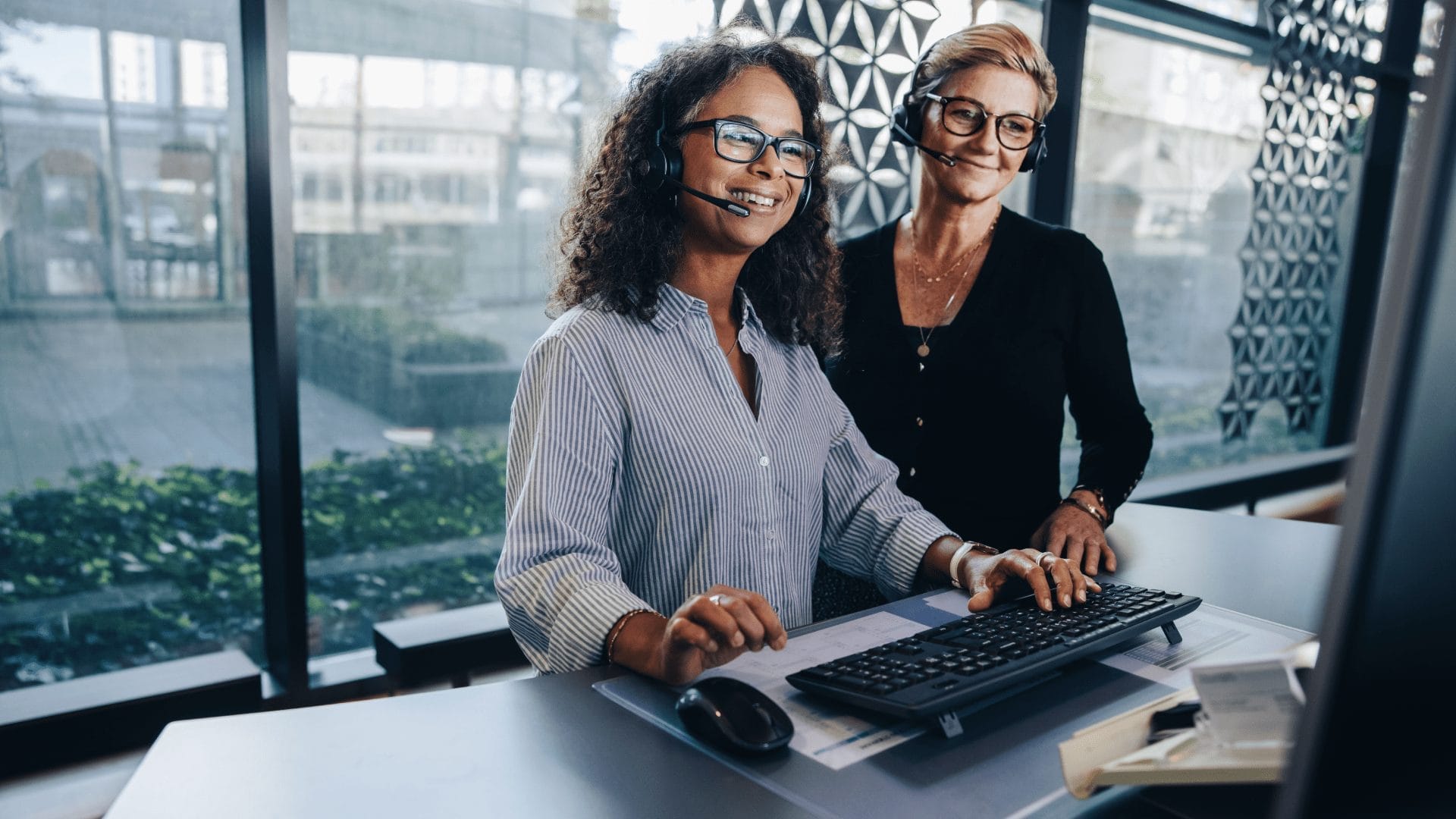Two people at a desk looking at a computer